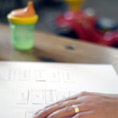 close up of woman's hand with baby beaker in the background